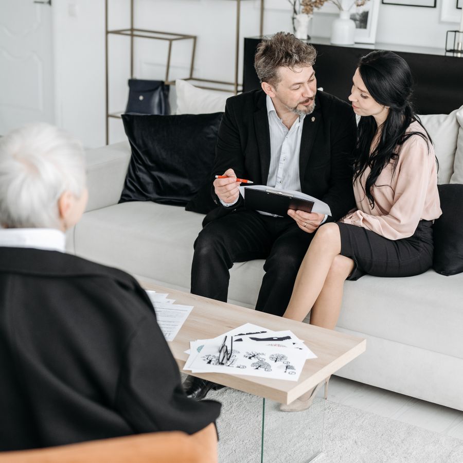 Finanzberater im Gespräch mit einem Paar auf dem Sofa